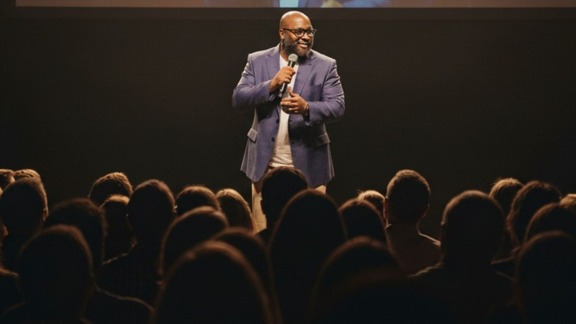 Phillip Edge on stage speaking to an audience